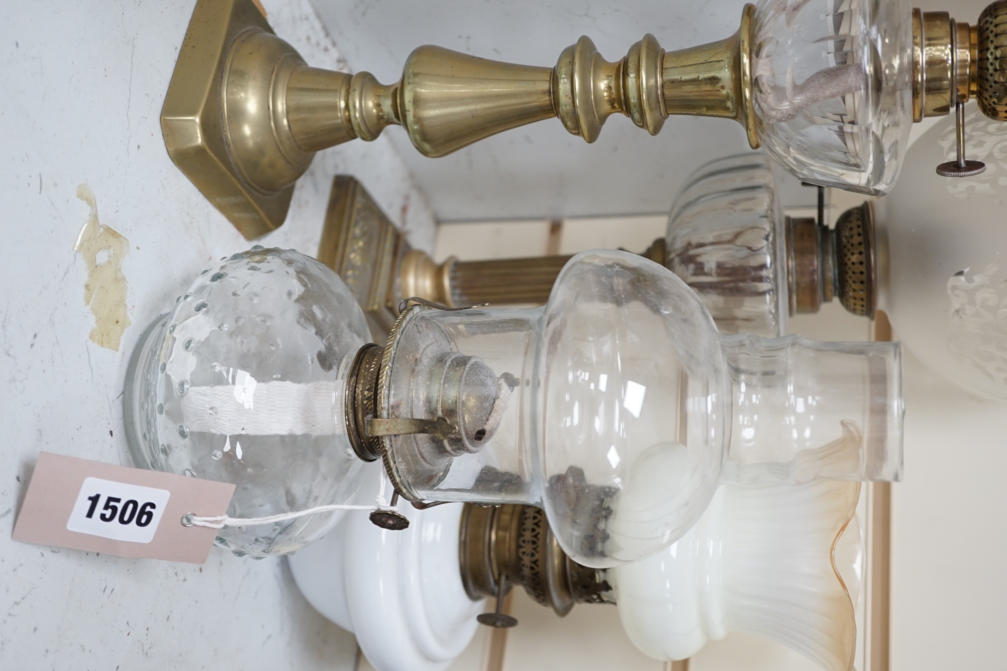 Four assorted glass and brass oil lamps, tallest 56cms high